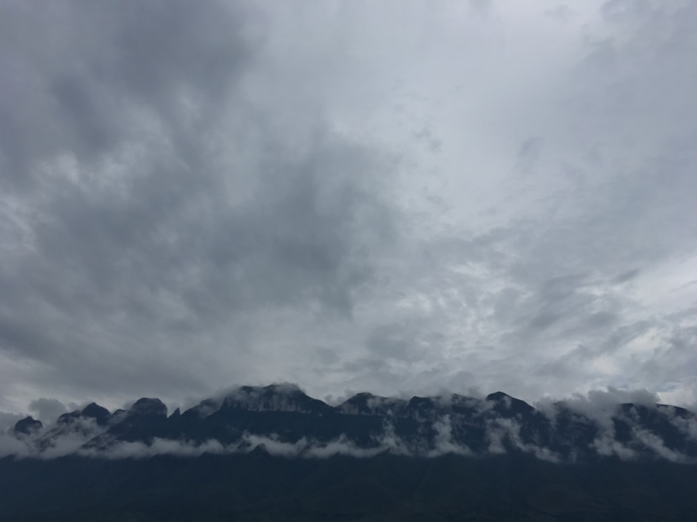 black and white mountains under white clouds