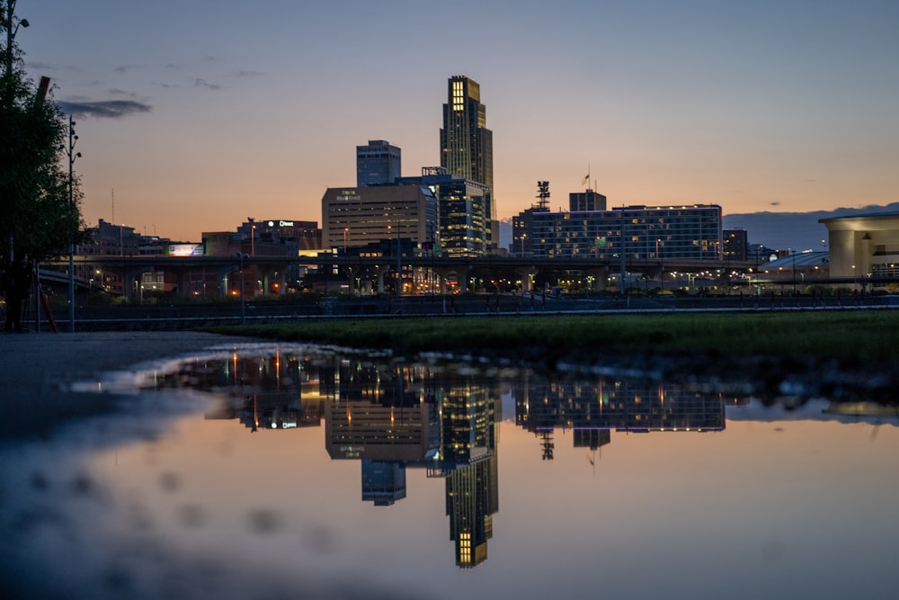 a city skyline is reflected in a body of water