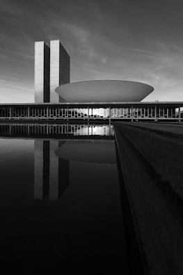 grayscale photo of building near body of water