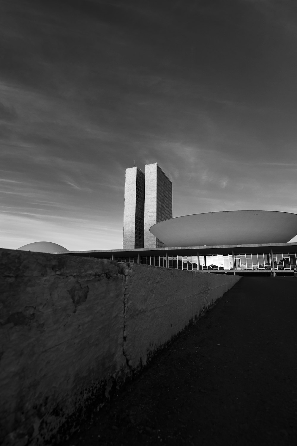 Foto in scala di grigi dell'edificio sotto il cielo nuvoloso