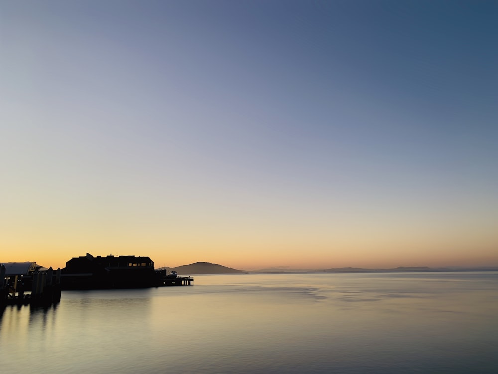 夕暮れ時の海上の船のシルエット