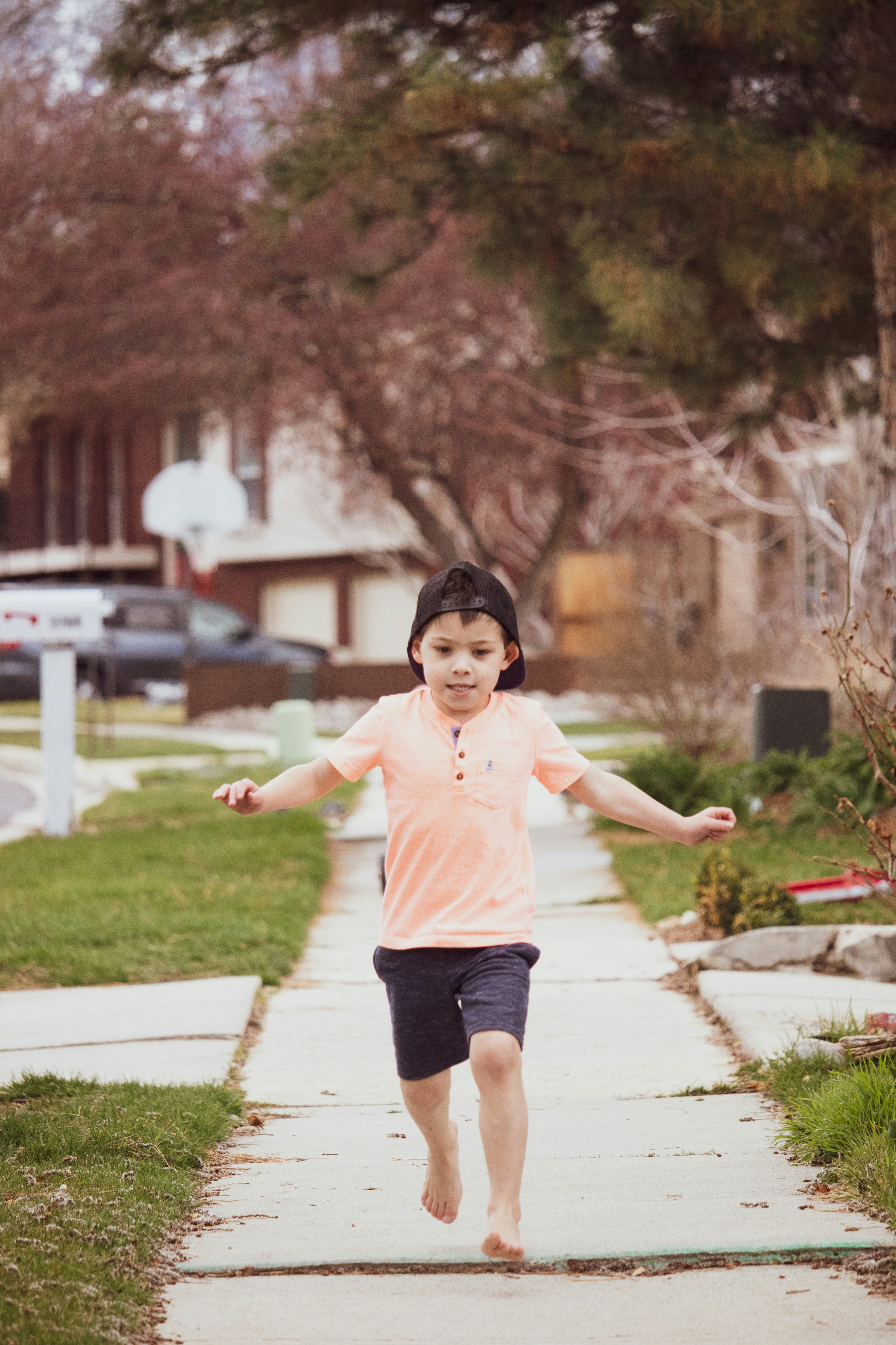 girl in pink shirt and black shorts running on pathway during daytime
