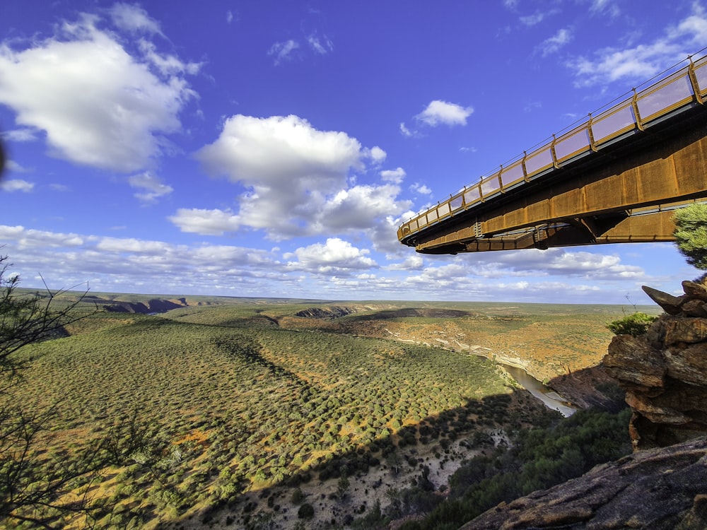 brown wooden bridge over the river under blue sky during daytime