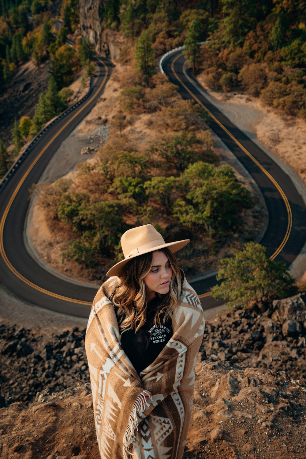 woman in brown hat and brown jacket standing on road during daytime