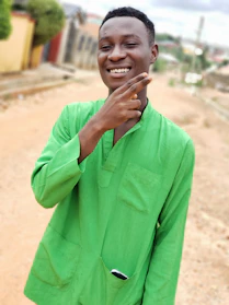 A woman wearing a green t-shirt with a subtle Lithuanian flag design, smiling outdoors.