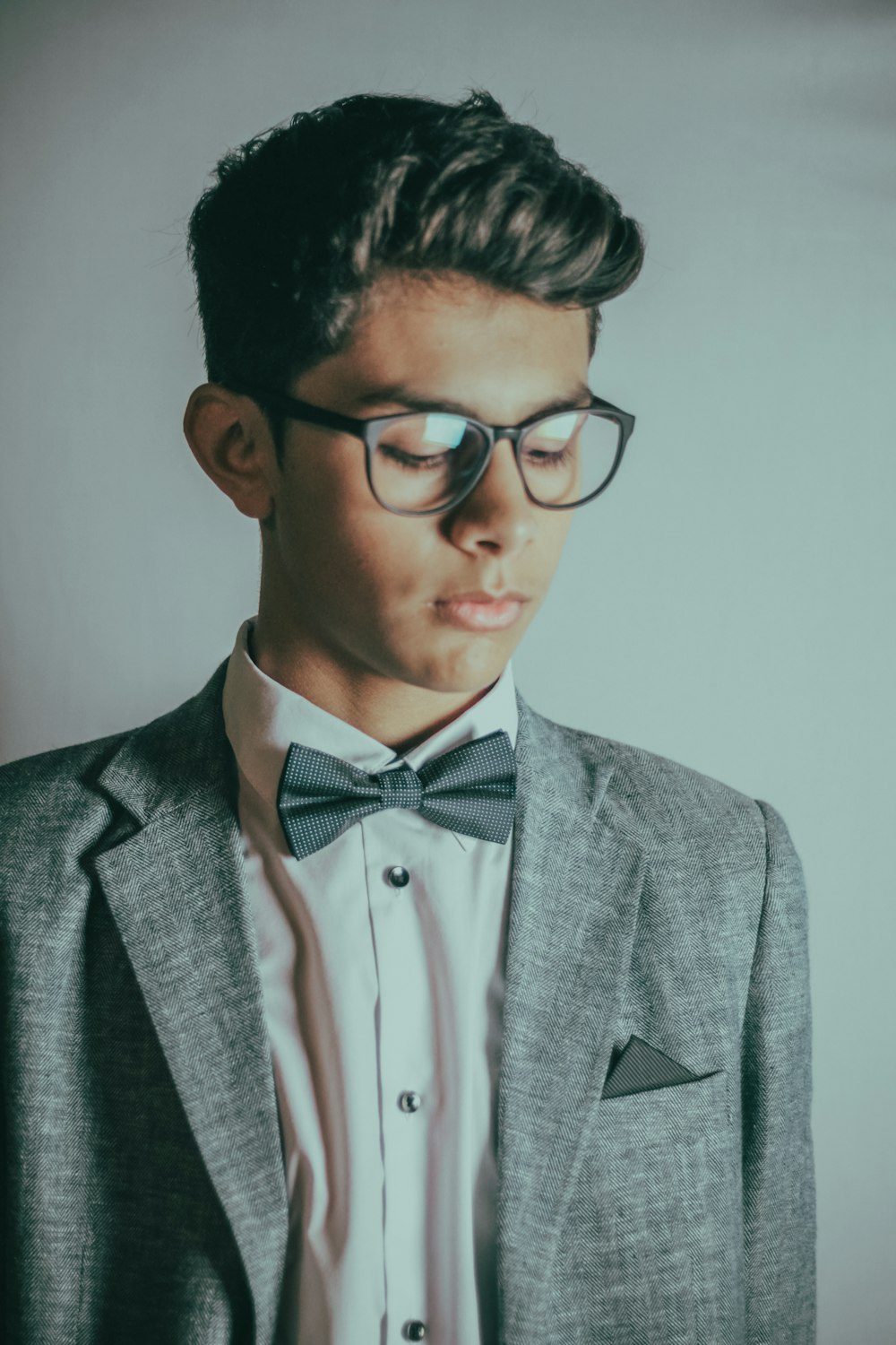 man in gray suit jacket wearing black framed eyeglasses