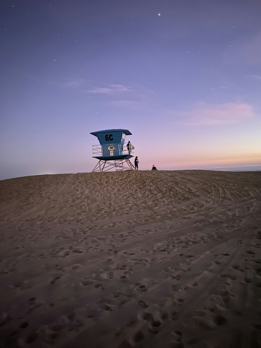 blue and white lifeguard house on sand