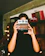 Smiling customer holding a vintage camera, standing in a cozy home office.