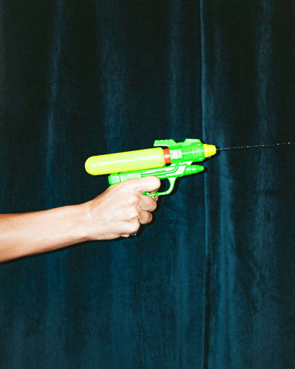 녹색 플라스틱 장난감 총을 들고 있는 사람