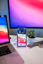 A modern office setup with digital tools and a small plant on the desk.