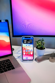 A modern office setup with digital tools and a small plant on the desk.