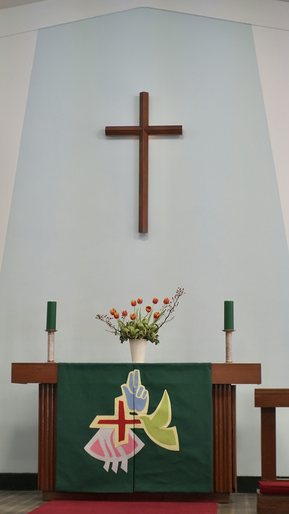 croce di legno marrone su parete bianca