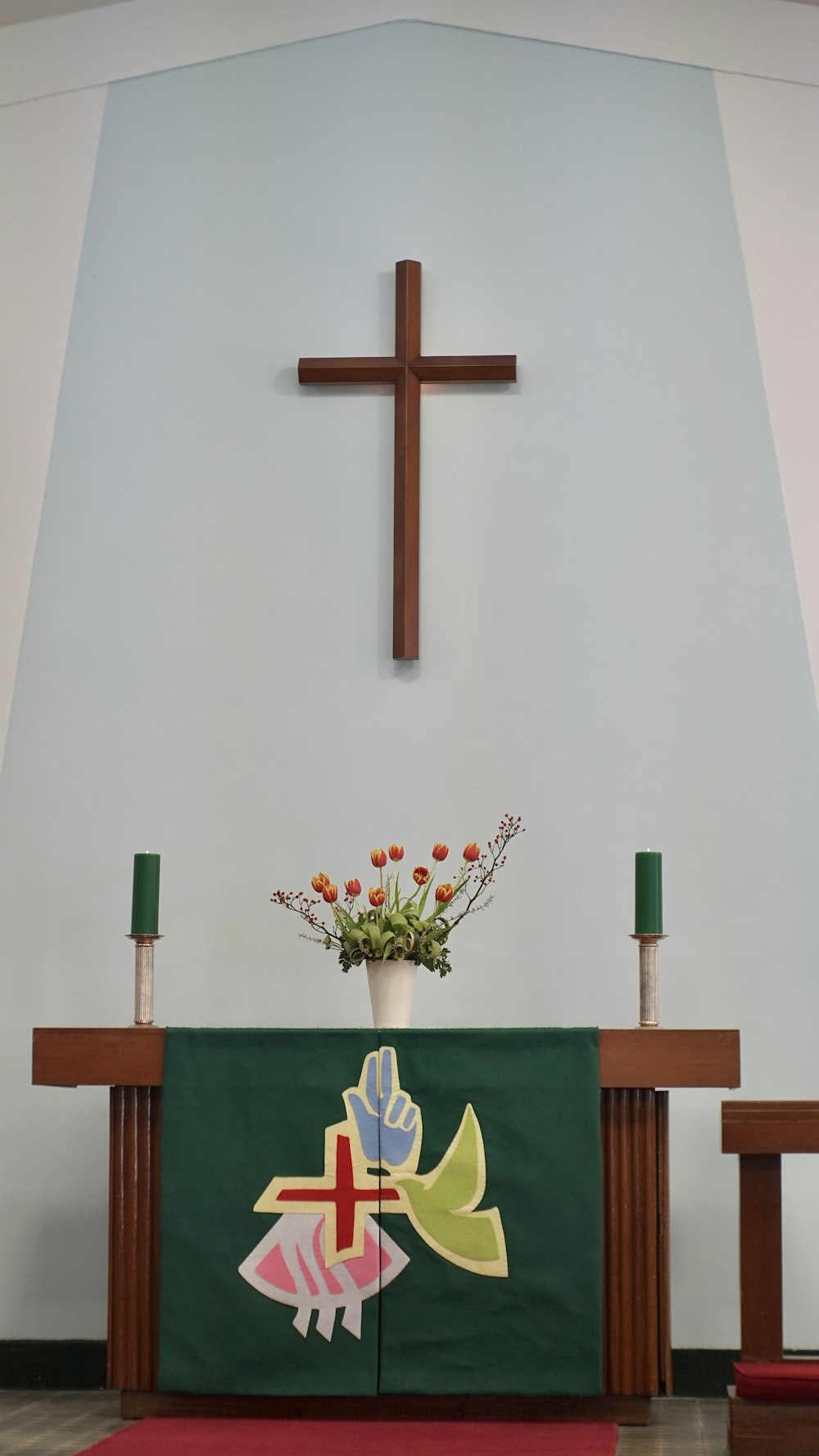 cruz de madera marrón sobre pared blanca