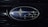 A close-up of an automotive logo featuring several intersecting silver stars on a blue background, surrounded by a chrome oval frame.