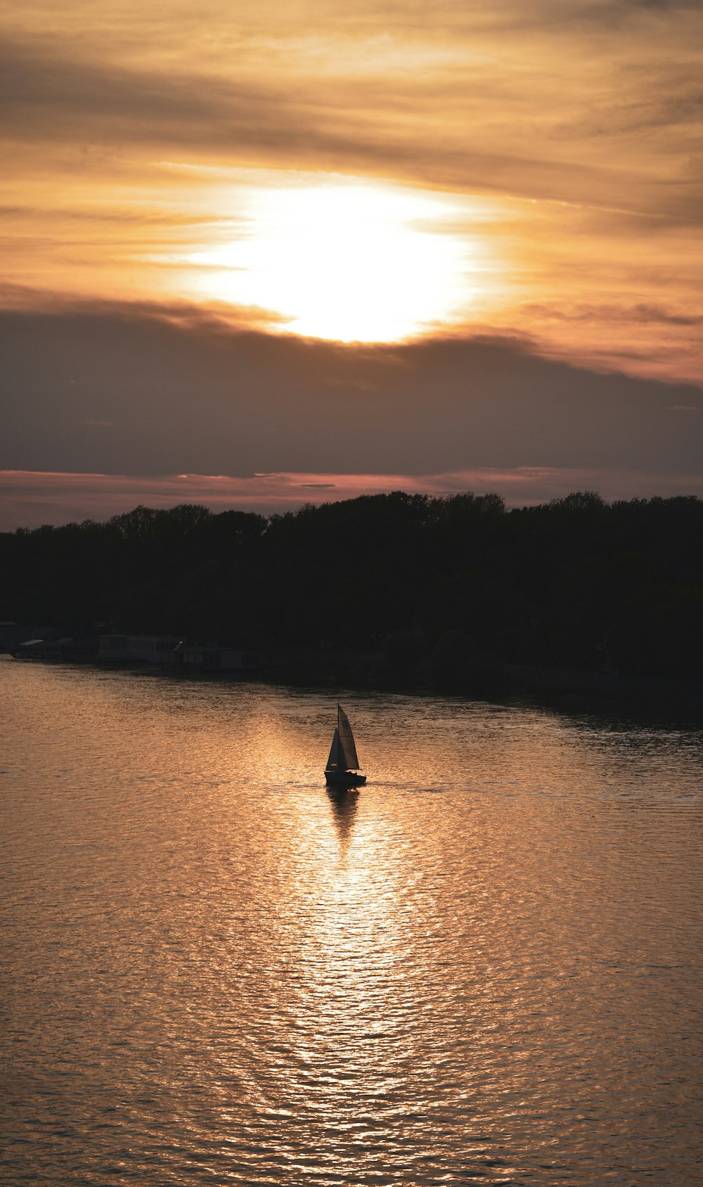 silhouette of boat on water during sunset