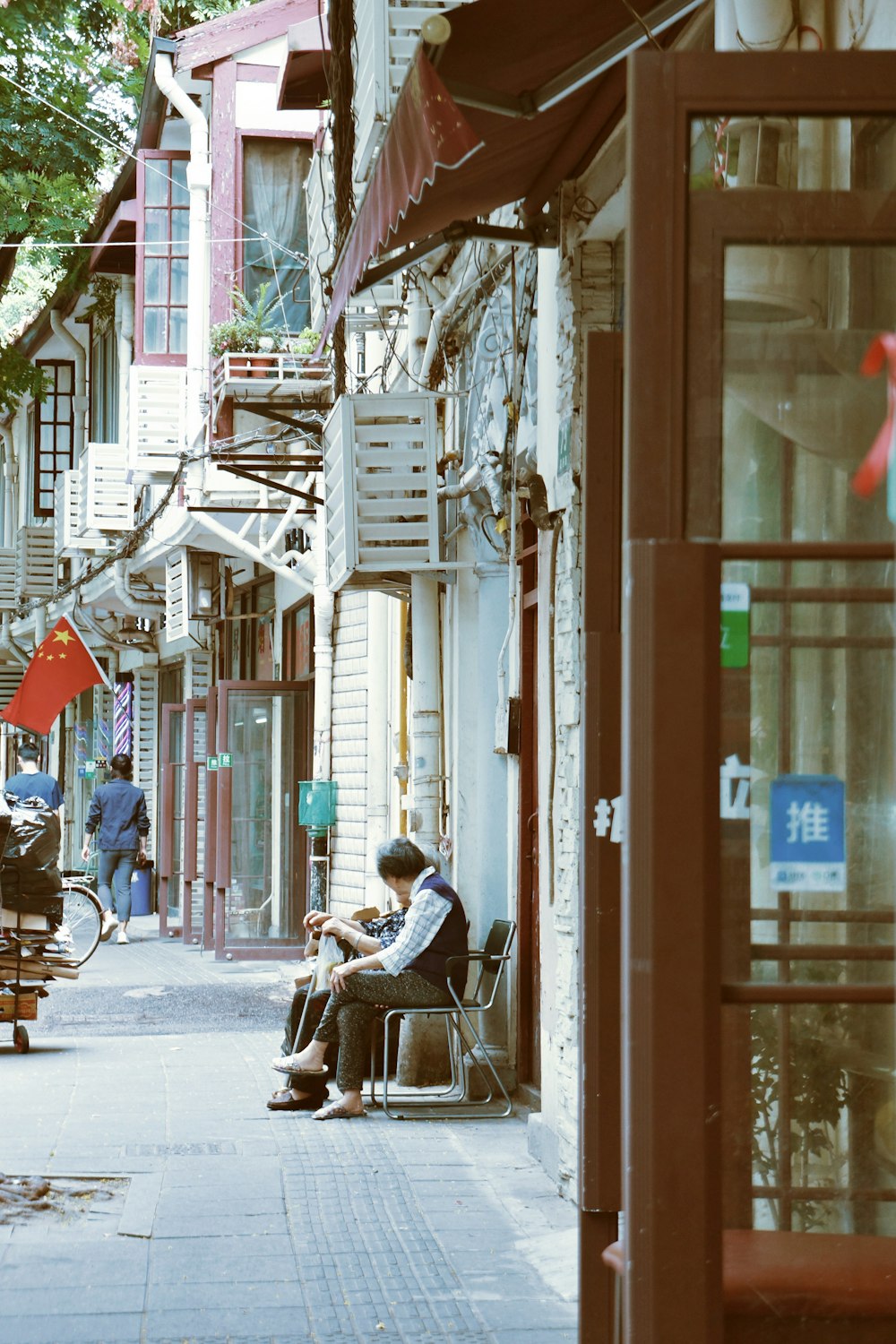 man in brown jacket sitting on chair near building during daytime