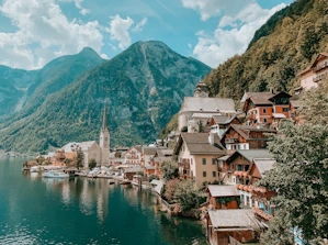 houses near body of water and mountain during daytime