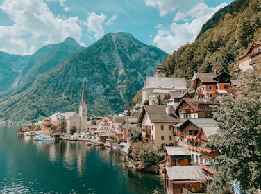 houses near body of water and mountain during daytime