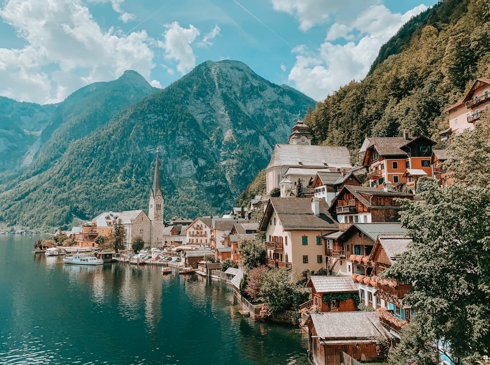 case vicino a specchio d'acqua e montagna durante il giorno