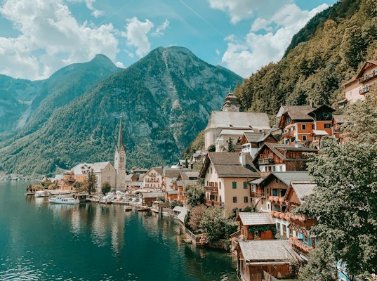 Houses near body of water and mountain during daytime — Hallstatt, Austria