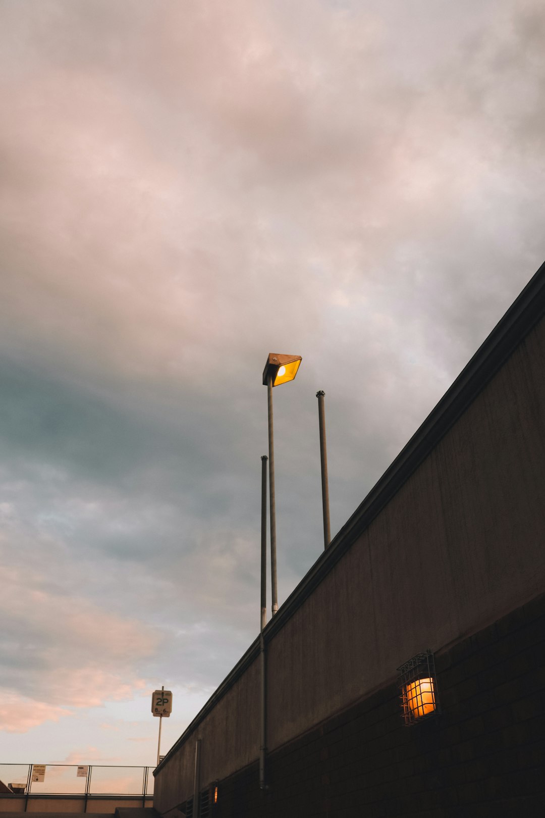 yellow street light under gray clouds