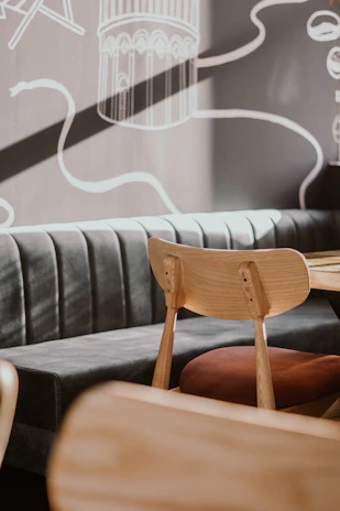 A cozy waiting area with natural wood furniture and soft green cushions, inviting relaxation.