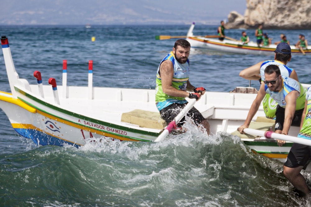 homme en gilet de sauvetage vert et blanc montant sur un kayak vert et jaune pendant la journée