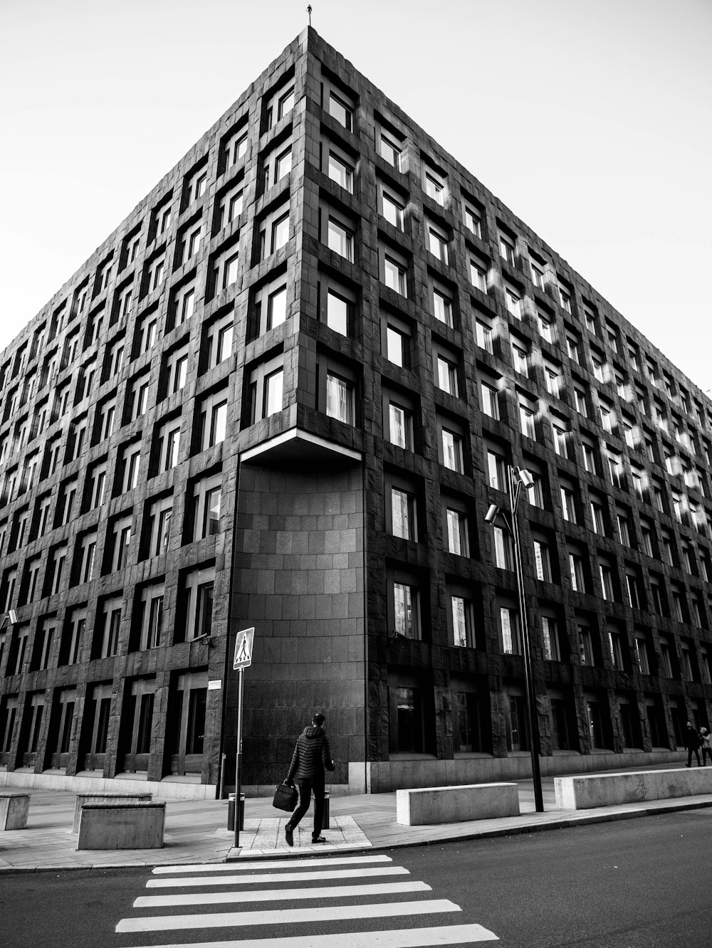 grayscale photo of man standing in front of building