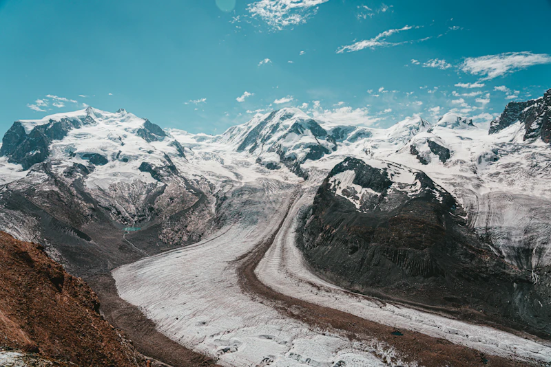 A road threading between snow-covered peaks above Zermatt