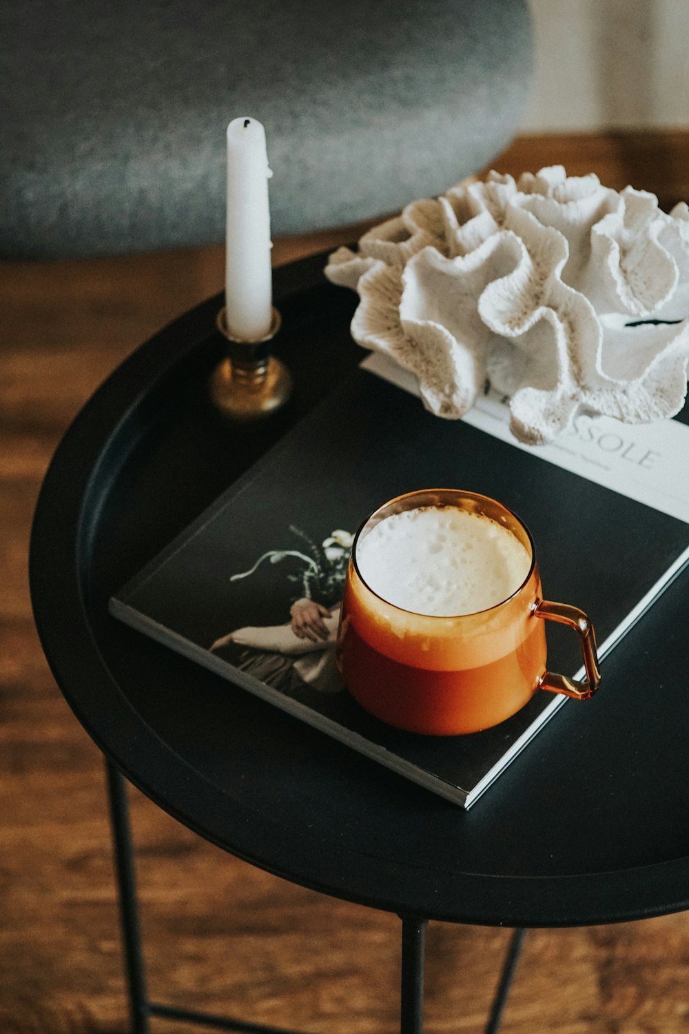 clear glass mug with brown liquid on black round table