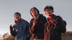 2 men and woman wearing black jacket