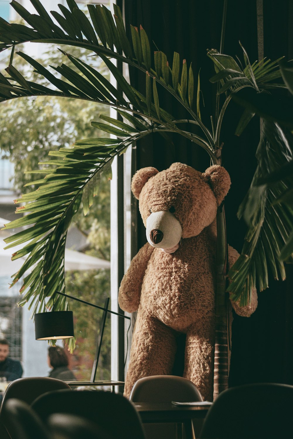Brauner Teddybär auf grünen Blättern