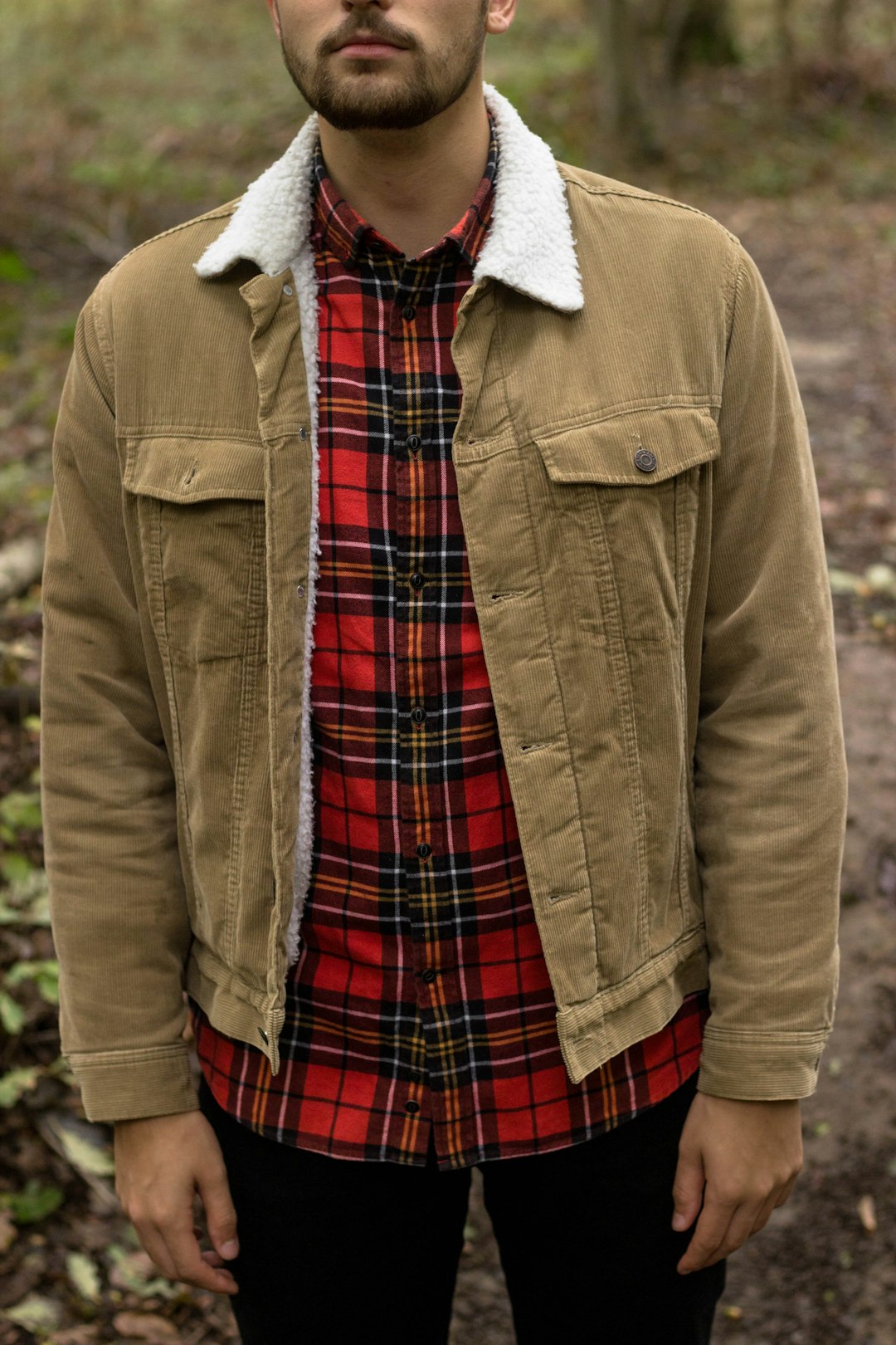 person in brown coat and red black plaid skirt