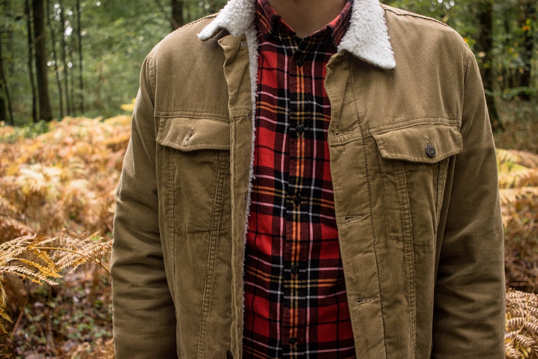person in red and black plaid shirt and brown jacket