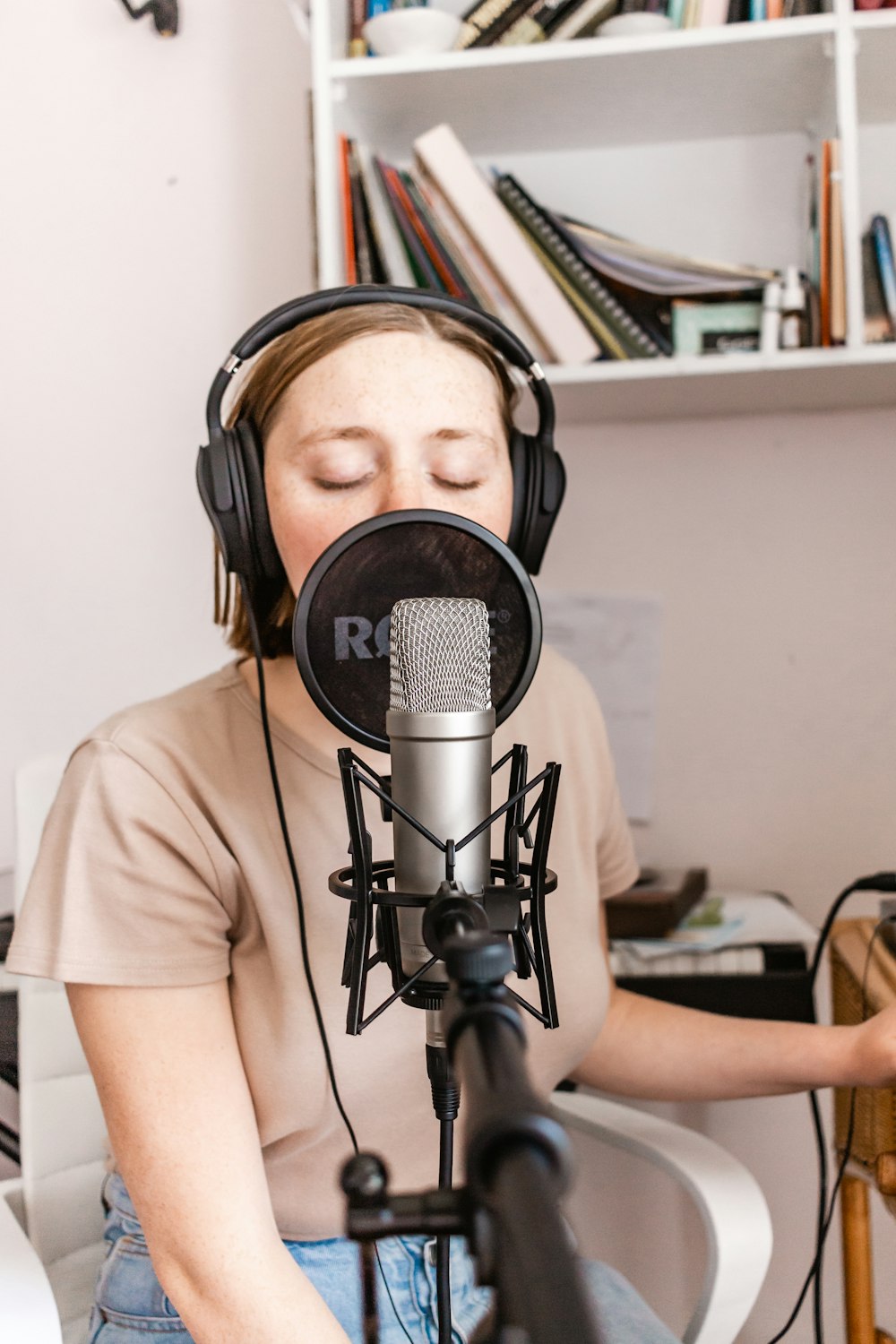 man in white crew neck t-shirt wearing black headphones