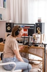 woman in white shirt sitting on chair in front of computer