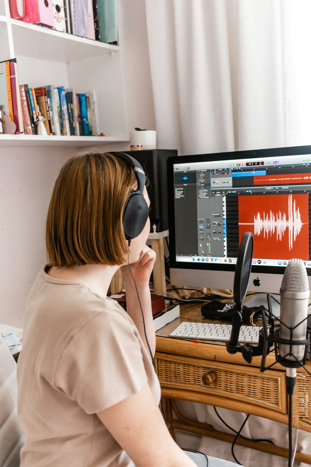 woman in beige long sleeve shirt wearing black headphones