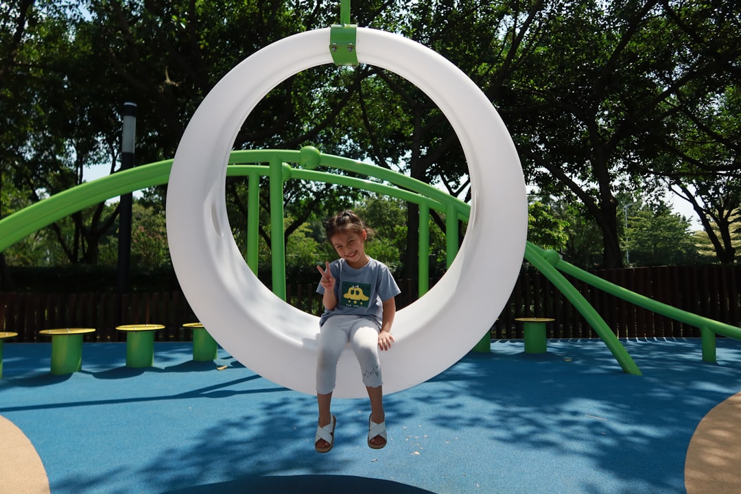 girl in white shirt and blue shorts sitting on white round inflatable ring