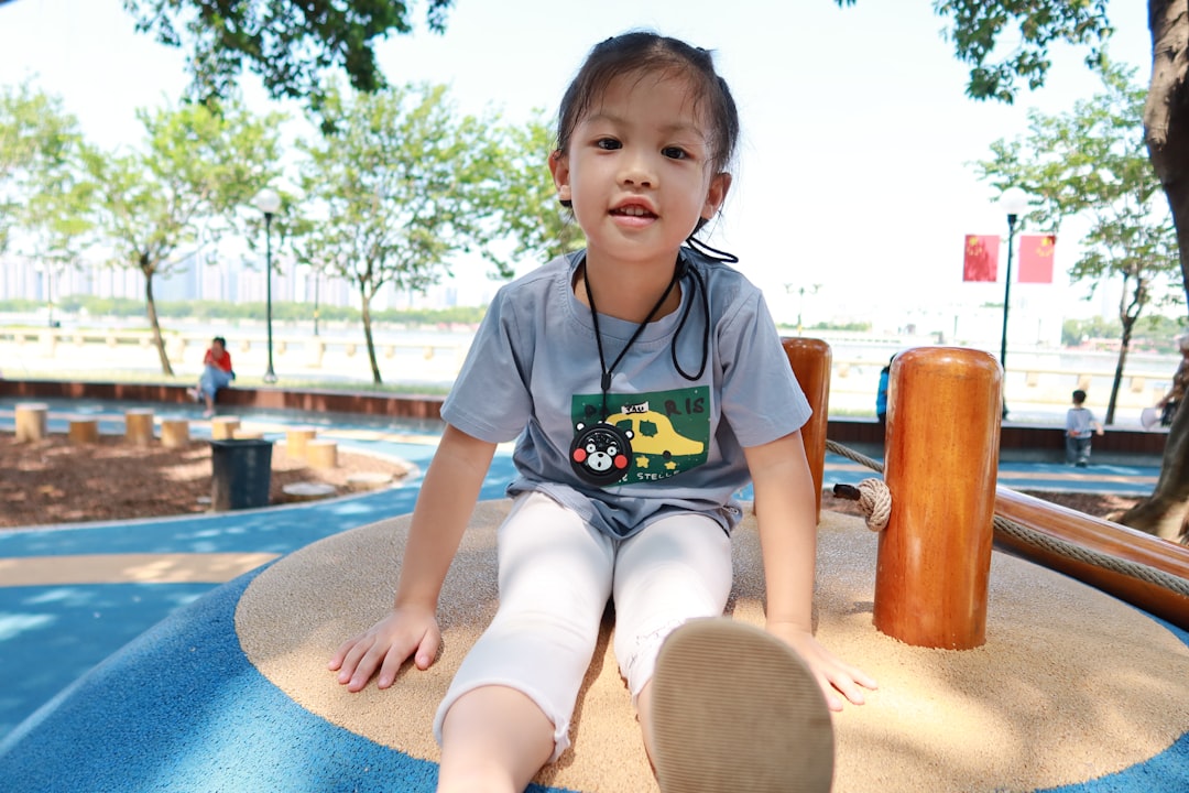 boy in gray t-shirt and white shorts sitting on brown wooden table