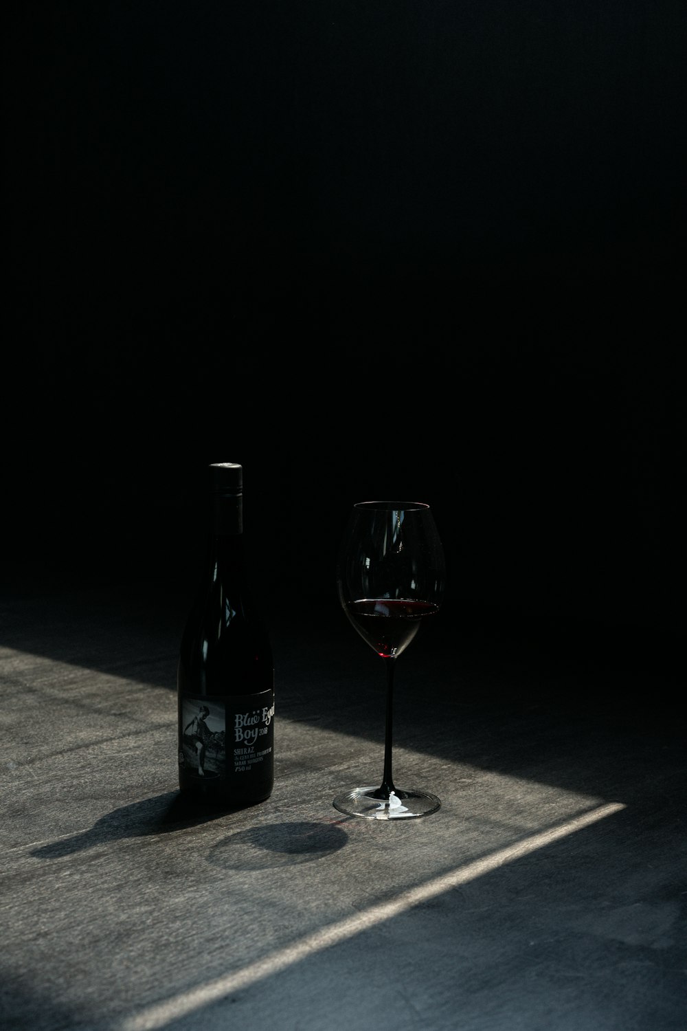 wine bottle beside wine glass on table