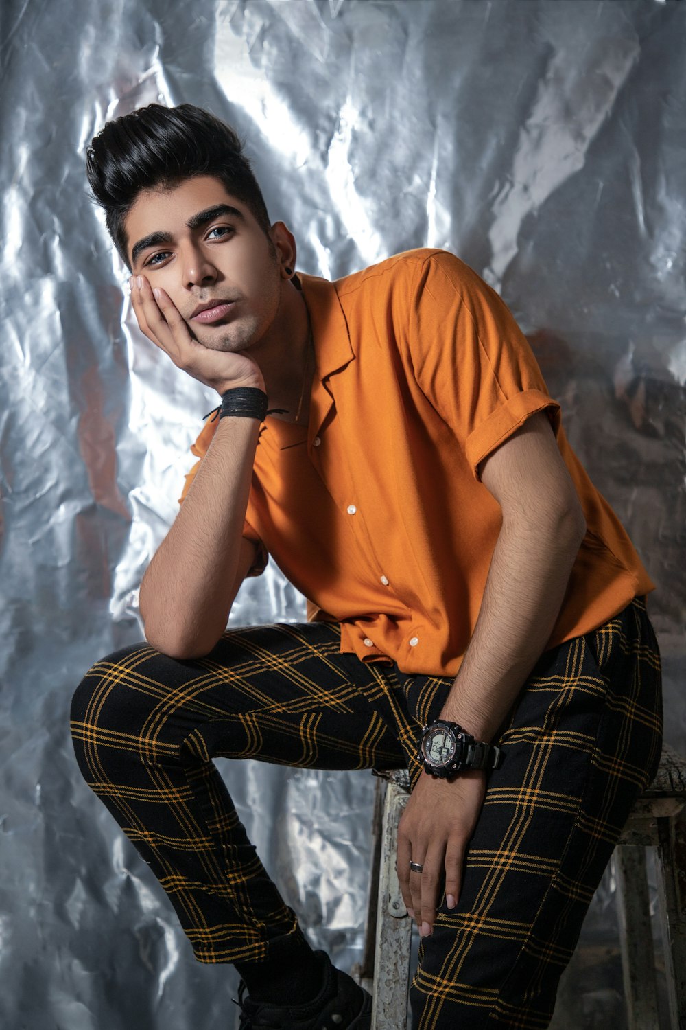 man in orange polo shirt and black and white plaid pants