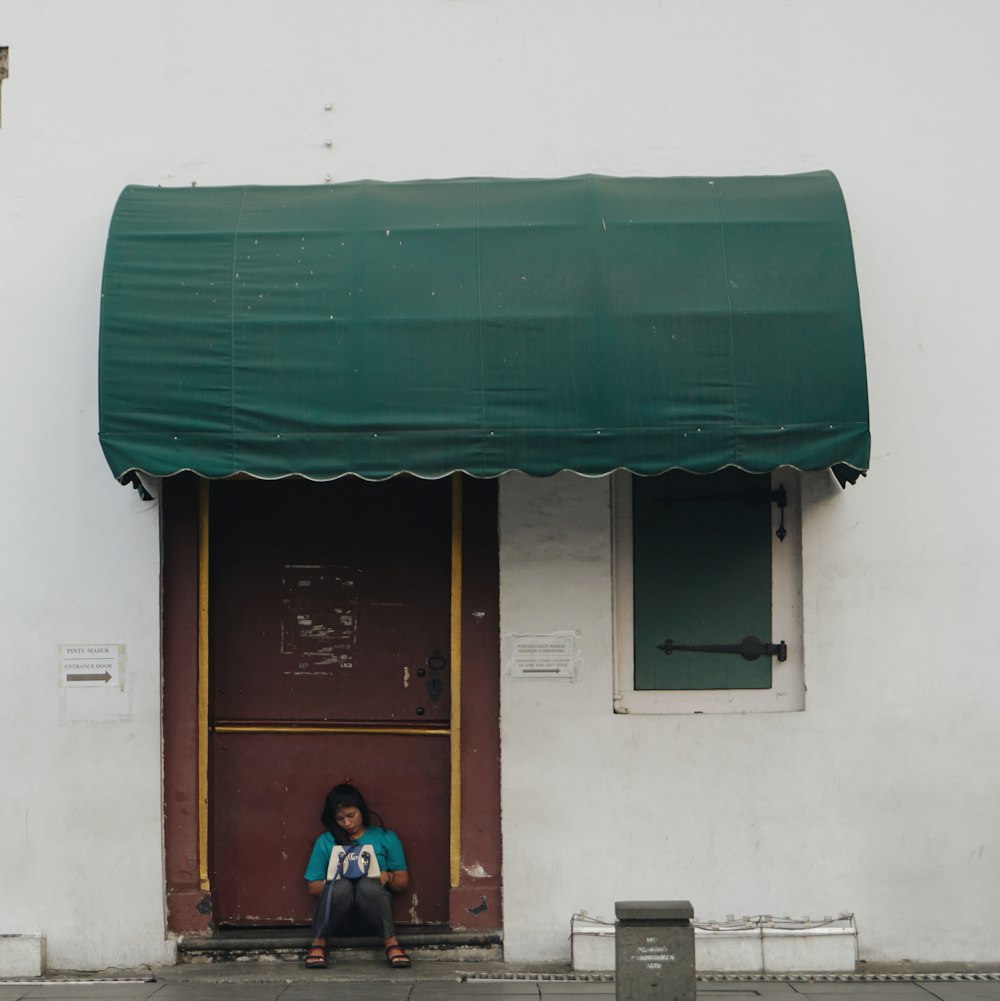 man in blue shirt sitting on bench near door