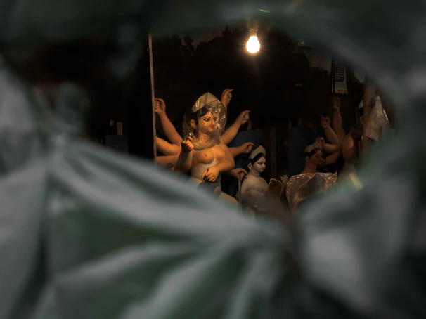 An intimate gallery corner showcasing figurative sculptures bathed in warm light, inviting quiet reflection.