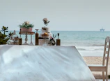 brown wooden table with chairs on white sand beach during daytime