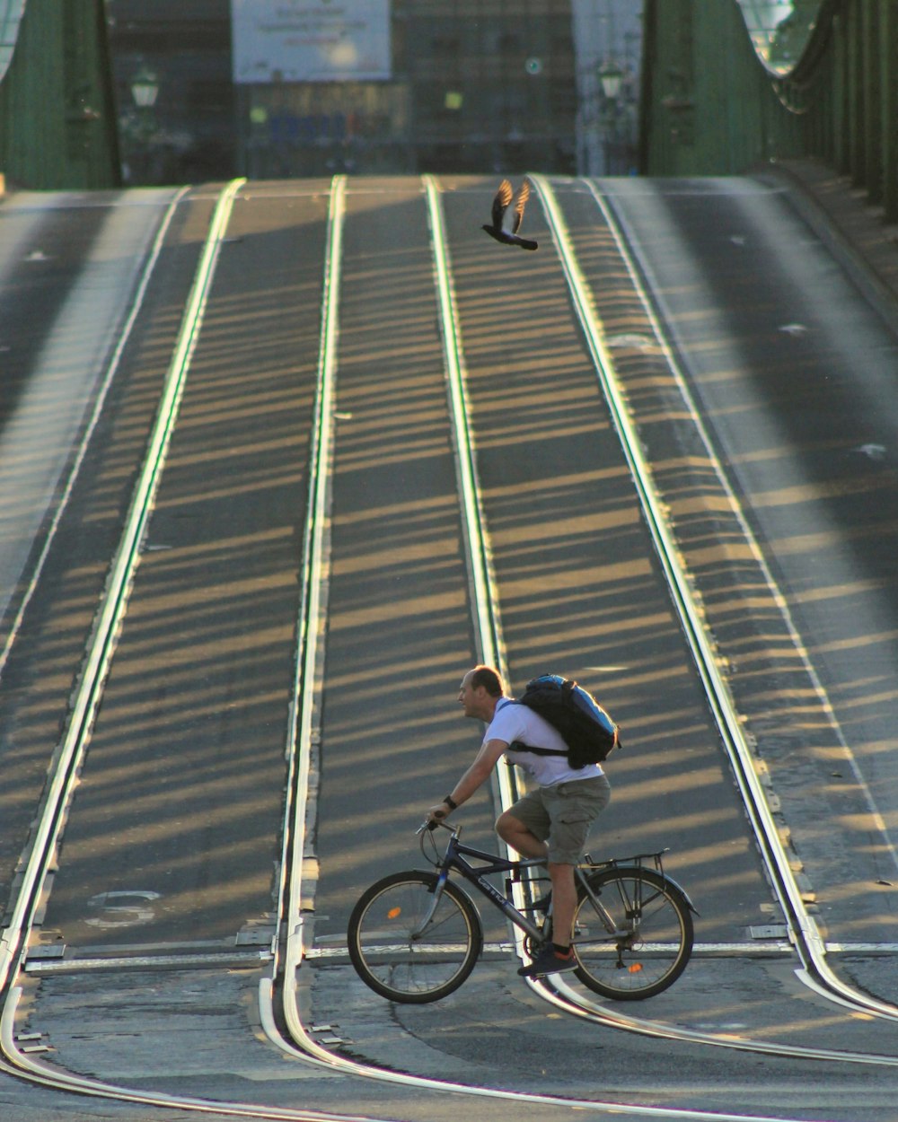 man in brown jacket riding on black bicycle on road during daytime