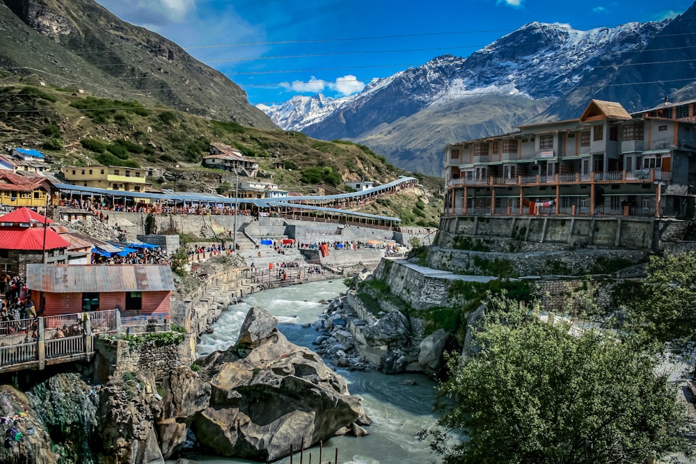 Casas cerca del río y la montaña bajo el cielo azul durante el día