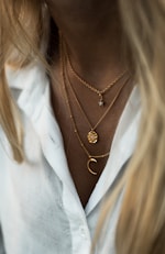 woman wearing gold necklace and white shirt