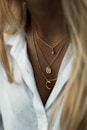 woman wearing gold necklace and white shirt