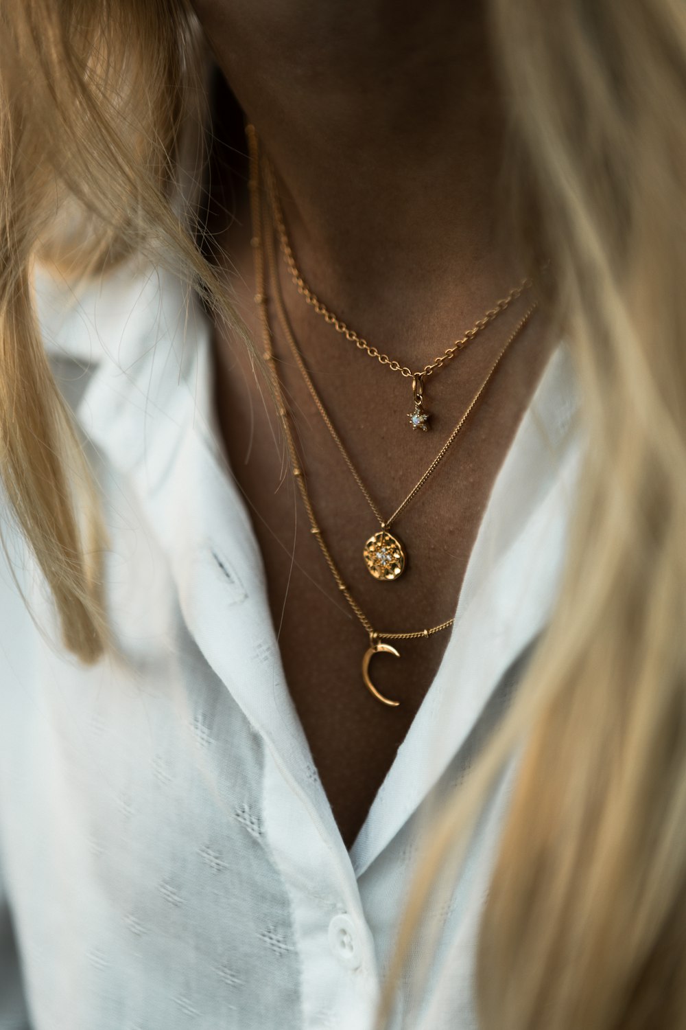 Mujer con collar de oro y camisa blanca