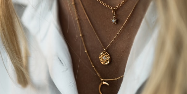 woman wearing gold necklace and white shirt